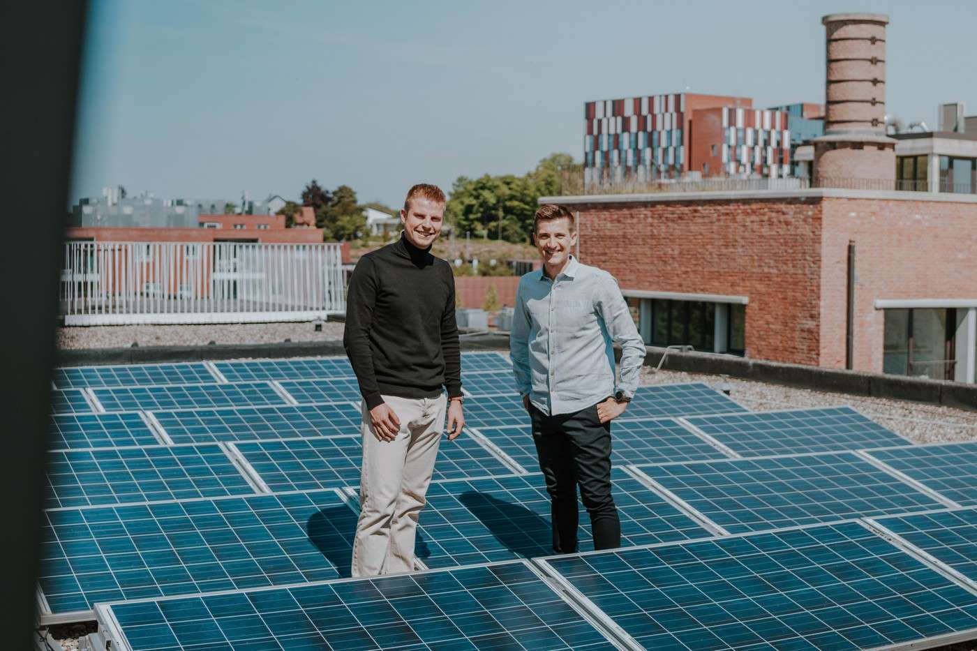 Kristof Borgions and Lars Cappelle standing between solar panels on a roof